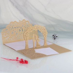 Detail of laser-cut wedding invitation featuring a couple under a floral archway