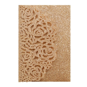 Detail of glitter gold hollow laser-cut rose patterns on elegant invitation card