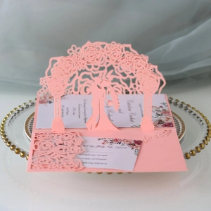 Close-up of 3D pop-up wedding invitation featuring laser-cut floral arch and pink details