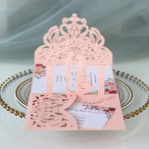 Detail of laser-cut wedding invitation with gate design and romantic couple silhouette