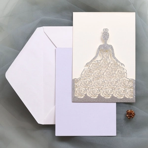 Détail de l'invitation de mariage découpée au laser avec paillettes et motif robe