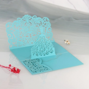 Detail of laser-cut 3D pop-up wedding invitation card featuring a blue dress design