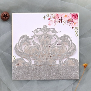 Detailed laser-cut silver glitter wedding invitation with elegant floral watercolor insert