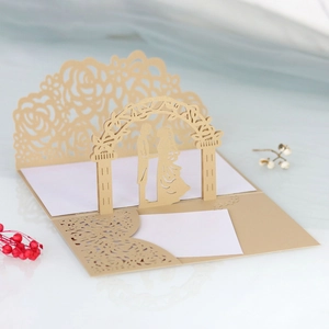 Dettaglio dell'invito di nozze 3D tagliato al laser con rose dorate e silhouette di coppia