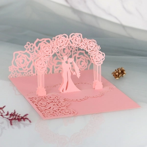 3D laser-cut wedding card featuring pink roses and bride and groom silhouette detail
