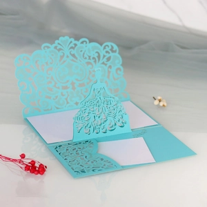 Macro detail of laser-cut 3D wedding card featuring light blue lace and princess dress design