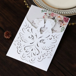 Macro view of laser-cut wedding invitation featuring a white floral hollow-out sleeve