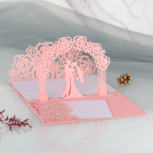 Detail of laser-cut 3D wedding card with rose arch silhouette in pink and white