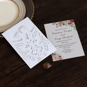Detailed laser cut wedding invitation with elegant couple silhouette and floral inner card