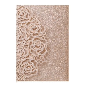 Detail of rose gold glitter cardstock with intricate laser-cut floral patterns for invitations
