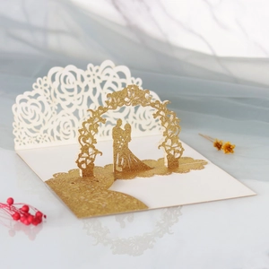 Détail macro d'une carte de mariage 3D avec mariés découpés au laser et paillettes dorées