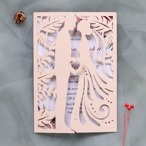 Macro shot of laser-cut wedding invitation with elegant couple silhouette and floral lace