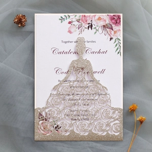 Détail de l'invitation de mariage découpée au laser avec carte florale et robe de mariée dorée