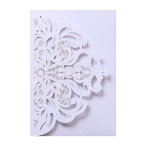 Detail of laser-cut white wedding invitation envelope with intricate lace floral patterns