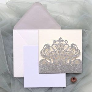 Detail of laser-cut silver glitter wedding invitation set with envelope and insert card