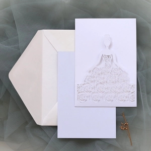 Macro view of laser-cut wedding invitation featuring elegant floral lace and female silhouette
