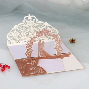 Detail of 3D laser-cut wedding invitation with rose gold glitter and pop-up couple silhouette