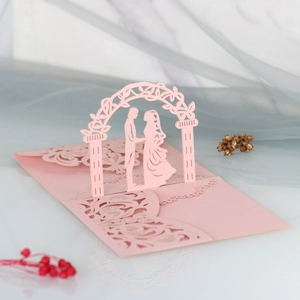 Macro view of 3D laser-cut wedding invitation featuring a romantic couple under floral arch