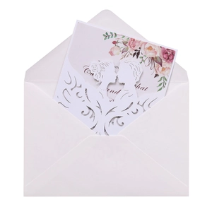Detail of laser-cut wedding invitation featuring silhouette of couple with floral inner card