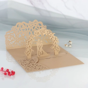 Dettaglio dell'invito di nozze 3D intagliato al laser con silhouette di coppia e arco floreale