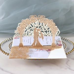 Macro detail of 3D laser-cut wedding invitation featuring rose arch and glitter finish