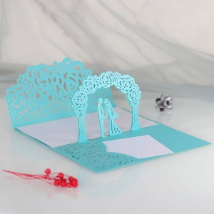 Detailed laser-cut 3D wedding card with light blue floral arch and couple silhouette