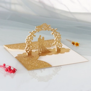 Détail de la carte de mariage découpée au laser avec paillettes dorées et arche florale