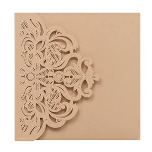 Close-up of laser-cut floral vine patterns on vintage kraft paper wedding invitation