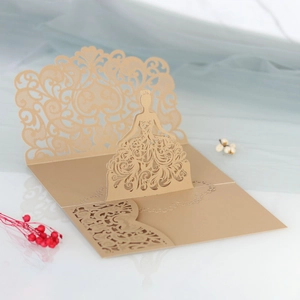 Detail of laser-cut pop-up card featuring a champagne gold dress silhouette design