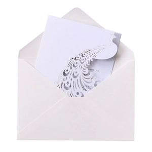 Macro detail of laser-cut peacock wedding invitation card with families typography