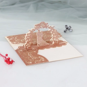 Detailed macro view of 3D laser-cut rose gold glitter wedding invitation with couple design