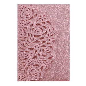 Close-up of laser-cut rose hollow pattern on pink glitter wedding invitation card