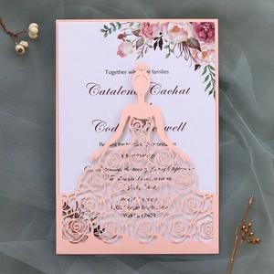 Detail of laser cut lace wedding invitation with pink floral dress pattern
