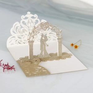 Detailed laser-cut wedding invitation with 3D couple silhouette and gold glitter finish