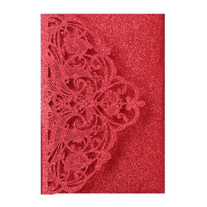 Detail of red glitter laser-cut floral wedding invitation cover with intricate hollow pattern