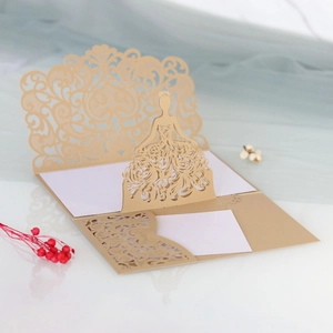 Macro shot of laser-cut champagne gold wedding invitation with 3D bridal lace dress detail