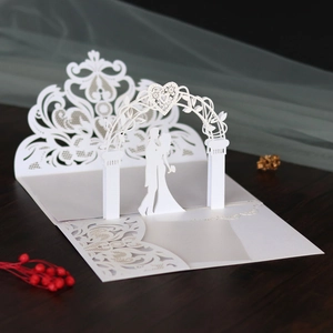 Macro view of 3D laser cut wedding invitation showing romantic kissing couple and lace