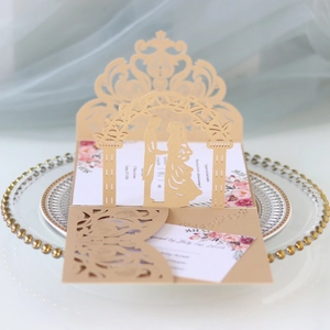 Macro detail of laser-cut pop-up wedding invitation with champagne lace floral pattern