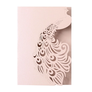 Detail of laser-cut peacock pattern on pearlescent pink wedding invitation card