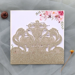 Detail of laser-cut wedding invitation cover with gold glitter finish and floral inlay