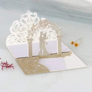 Detail of laser-cut 3D wedding invitation with glitter gold and couple silhouette