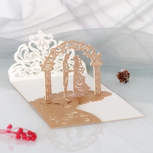 Makroaufnahme einer 3D Laser-Hochzeitskarte mit goldenem Glitzer-Brautpaar-Ausschnitt