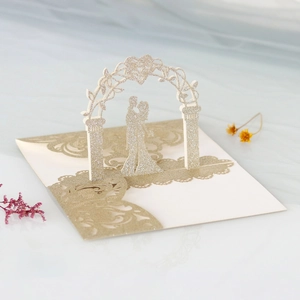 3D laser-cut wedding invitation featuring a champagne gold glitter silhouette under flower arch