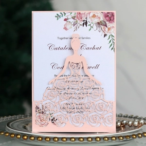 Detail of laser-cut rose hollow invitation with pink wedding dress shell and floral insert