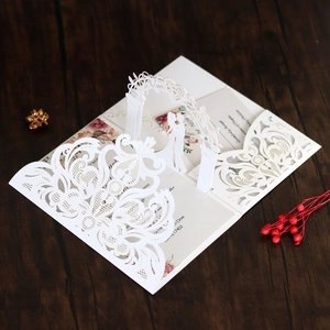 Detailed laser-cut wedding invitation featuring a 3D pop-up of a couple under an archway