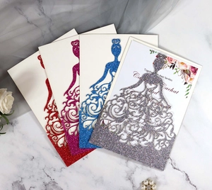 Gros plan d'invitations de mariage découpées au laser avec élégant motif de robe de mariée