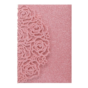 Macro detail of pink glitter laser-cut rose patterns on elegant wedding invitation card