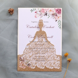 Détail d'une carte pailletée or rose découpée au laser en forme de robe avec fleurs