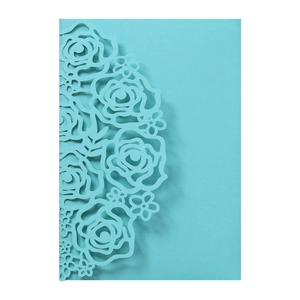 Detailed macro view of tiffany blue laser-cut rose patterns on elegant wedding cards
