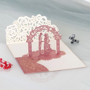 Detail of laser cut 3D pop-up wedding invitation featuring a romantic couple under an arch